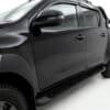 Close-up of matte black ABS body cladding panel on a Toyota Hilux rear door showing the textured finish and edge line